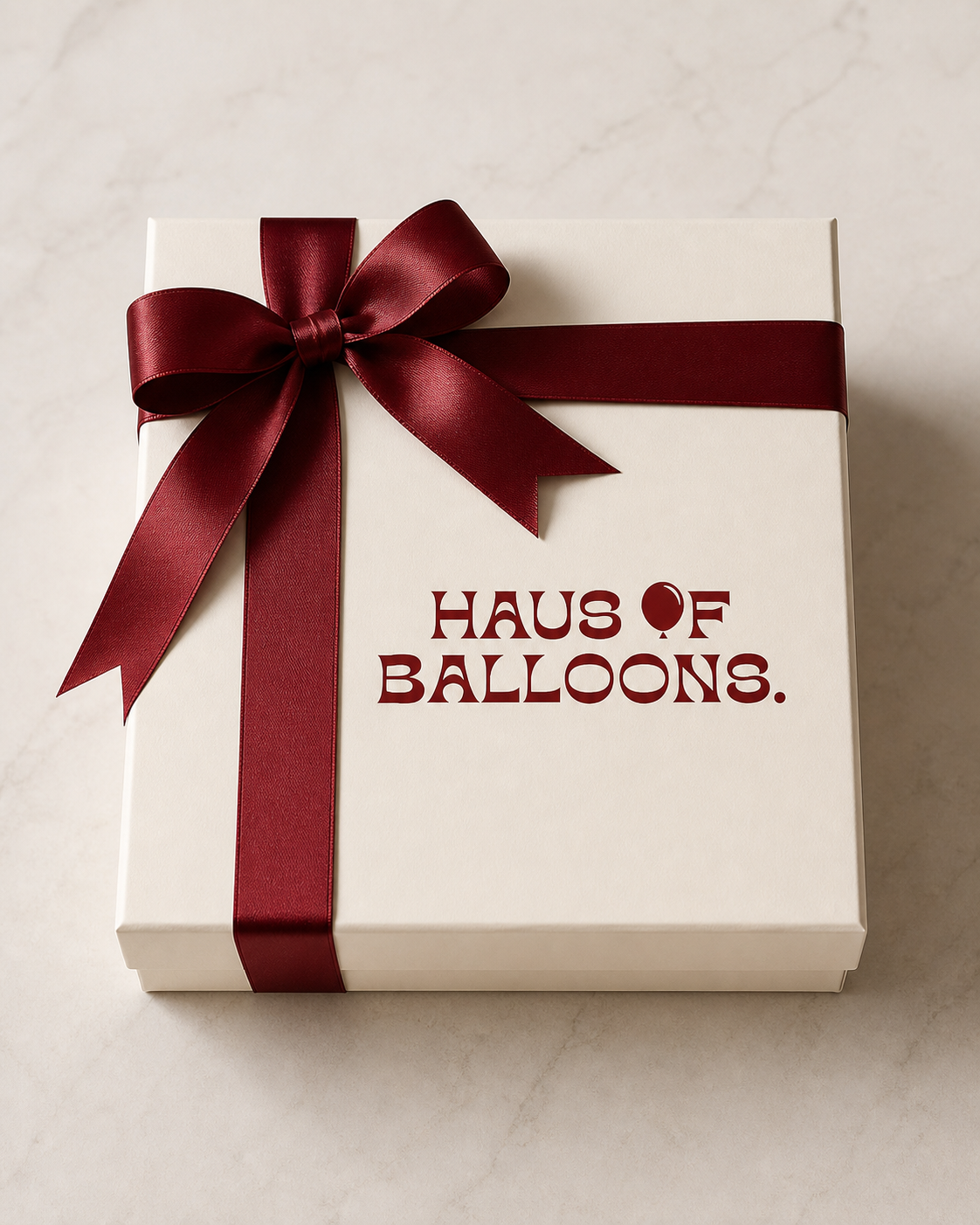 Ivory Haus of Balloons gift box tied with a burgundy ribbon